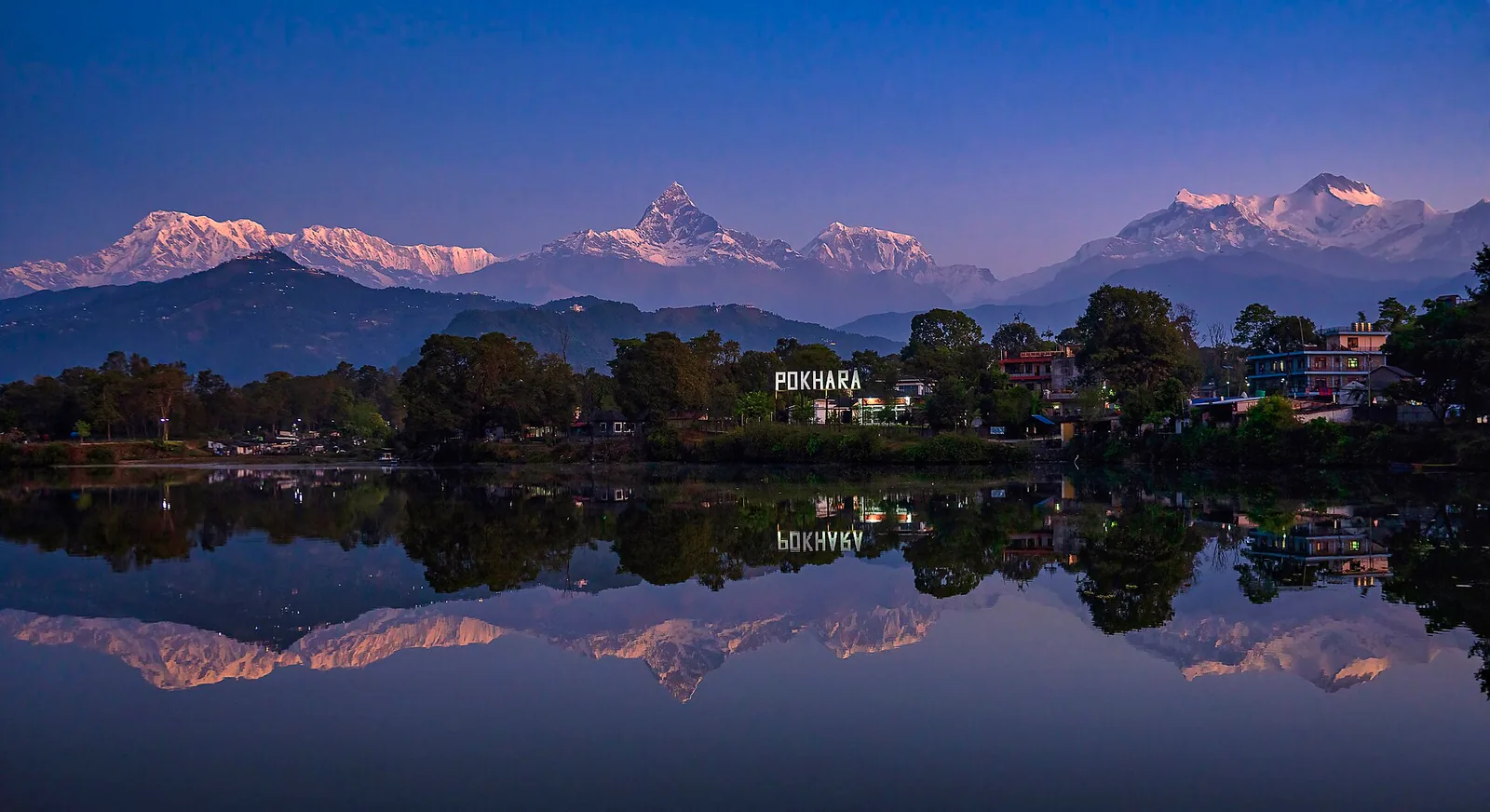Machhapuchhre and the Annapurna range reflected in Phewa Lake at dawn