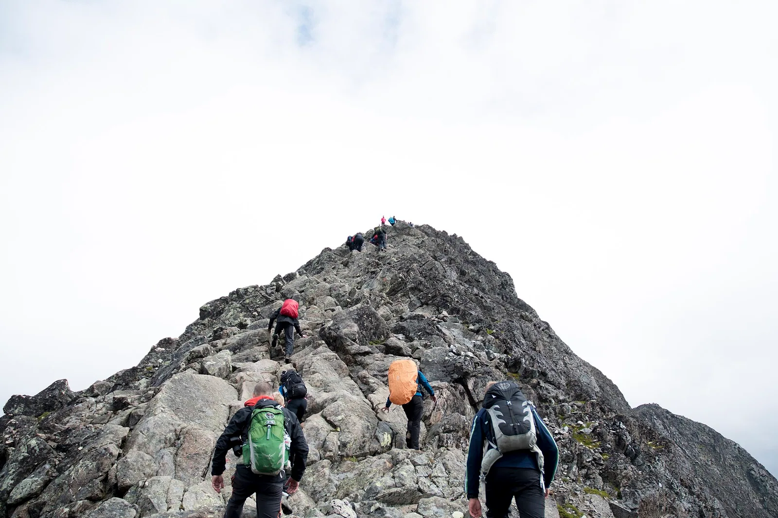 A group of backpackers hiking across a rocky mountain ridge